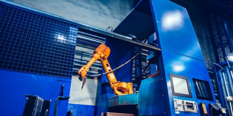 Robotyczne ramię w fabryce. Nowoczesny przemysł ciężki, technologia i uczenie maszynowe