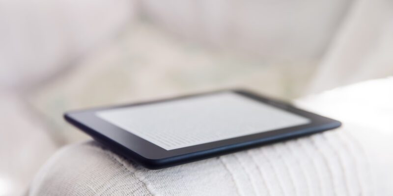 czytnik ebook leżący na podłokietniku fotela